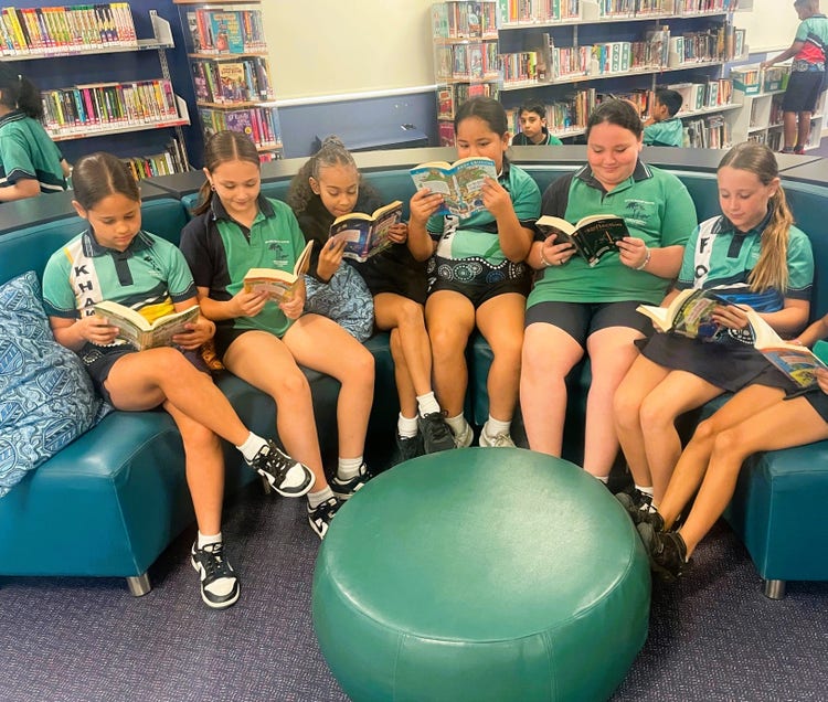 6 students reading books in the library