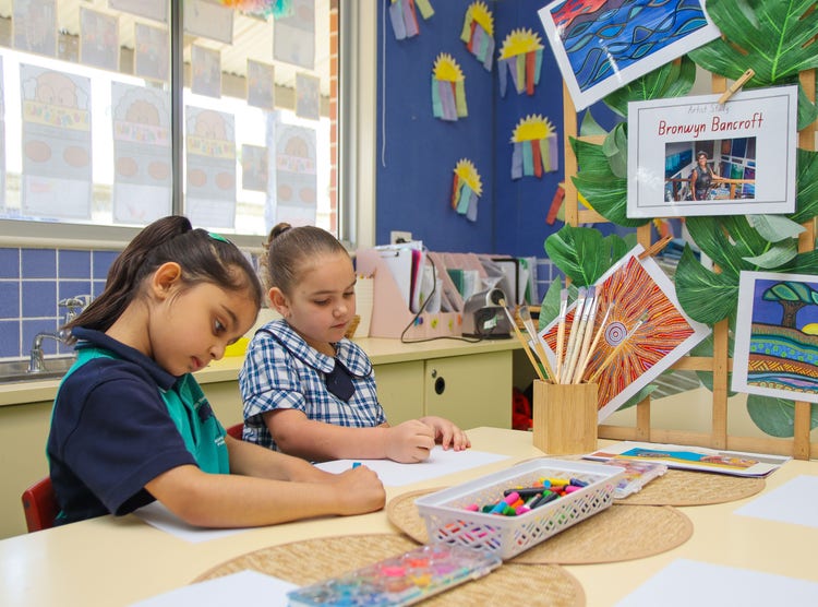2 students doing art with crayons