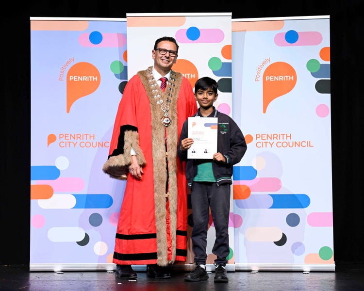 a student with a man standing on a stage with a certificate