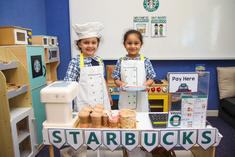 2 girls playing in a pretend starbucks shop