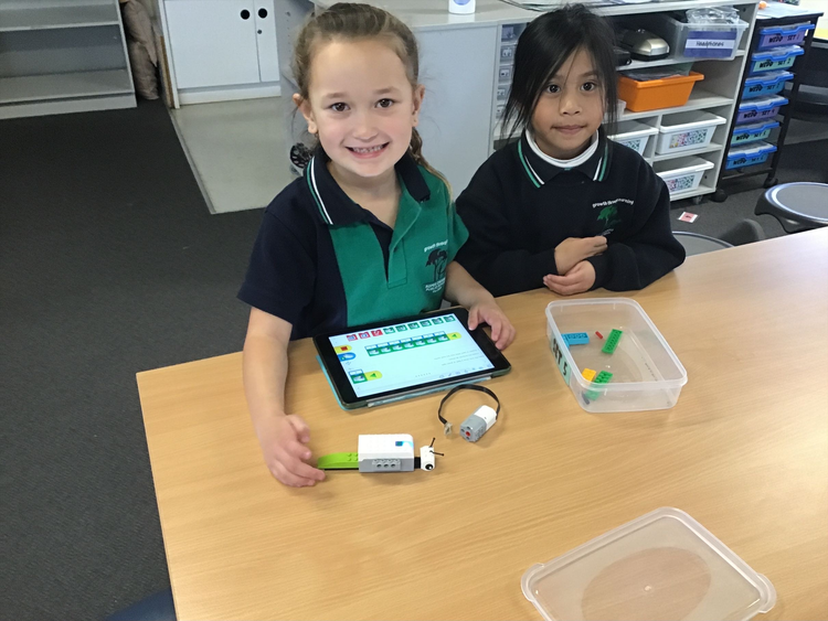2 students using lego robotics and an iPad