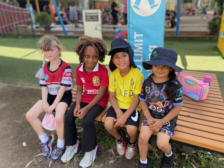 4 kids dressed in different sport jerseys