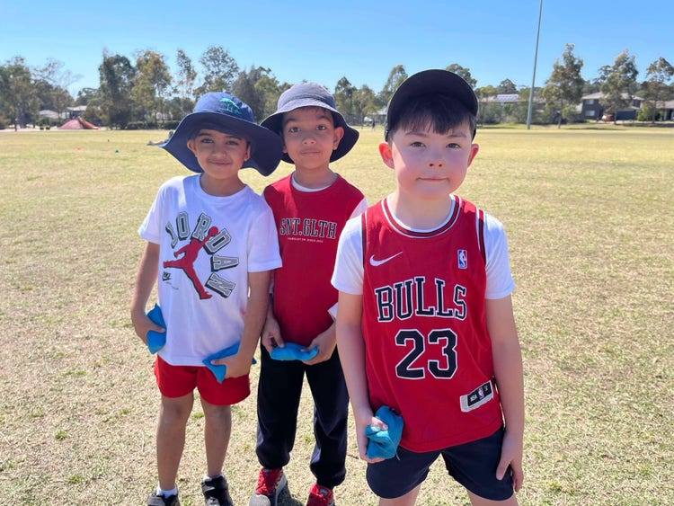 3 boys standing outside wearing red shirts
